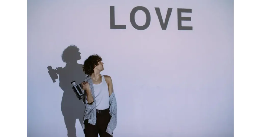 Man with video camera under a love sign