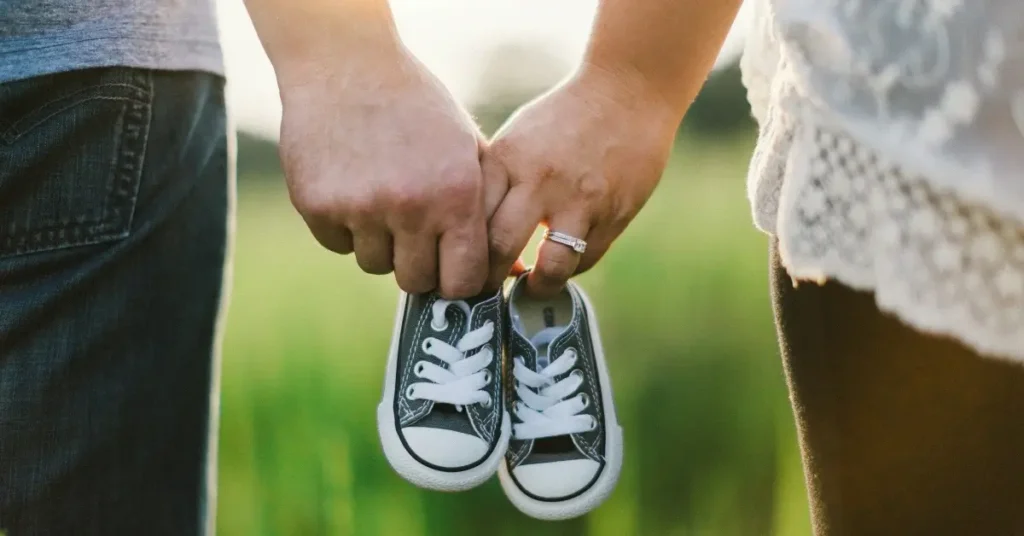 Parents holding baby shoes